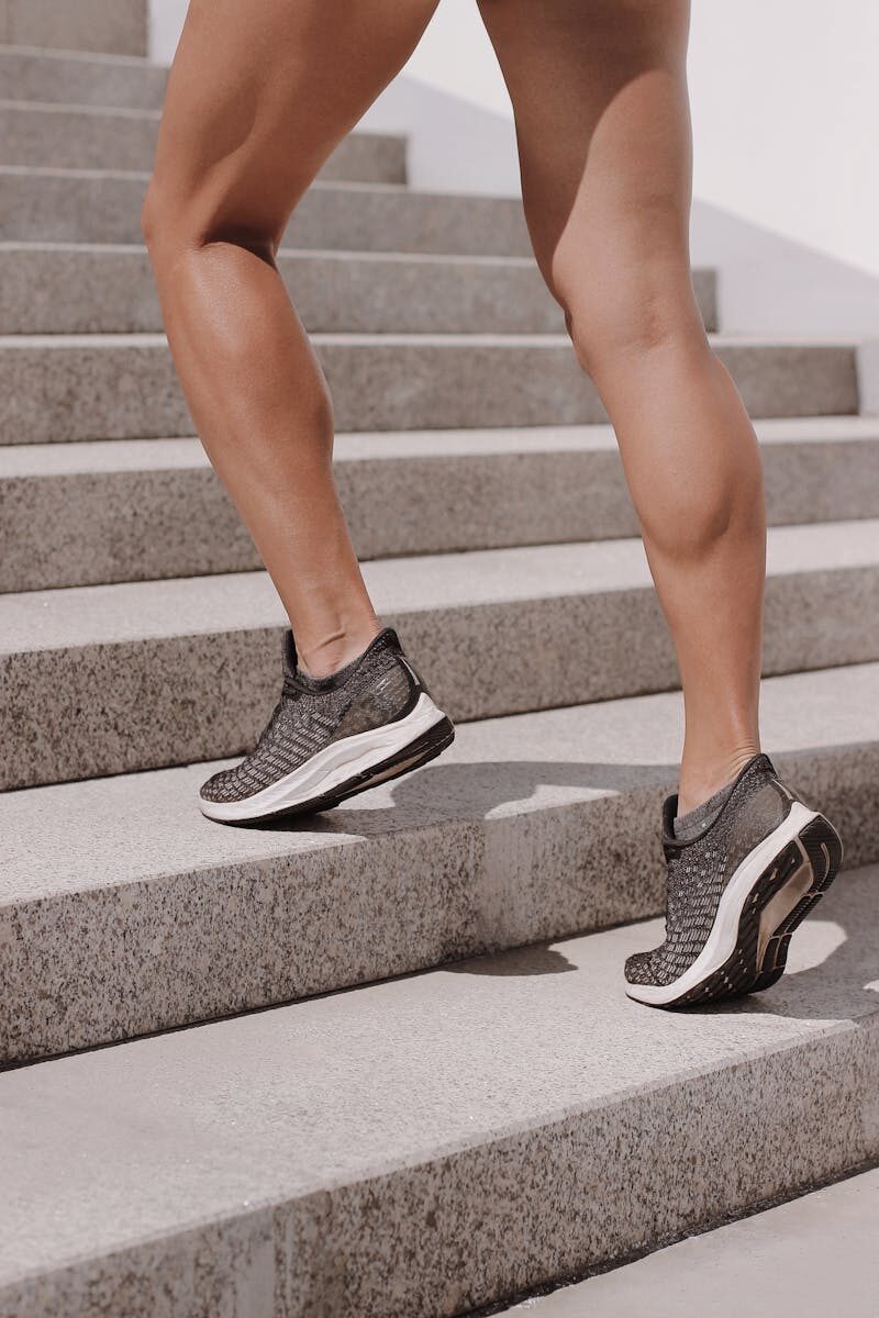 Dynamic shot of athletic legs in sneakers climbing stairs, perfect for fitness and lifestyle themes.